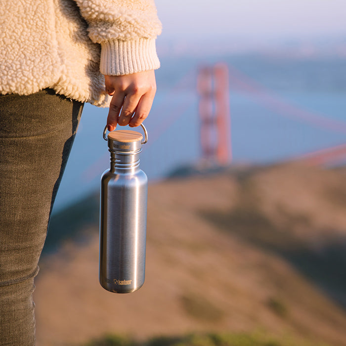 27oz-reflect-with-bamboo-cap-o3 K27SSLRF-BS-BAMBOO_reflect_bottle_bridge_lifestyle.jpg